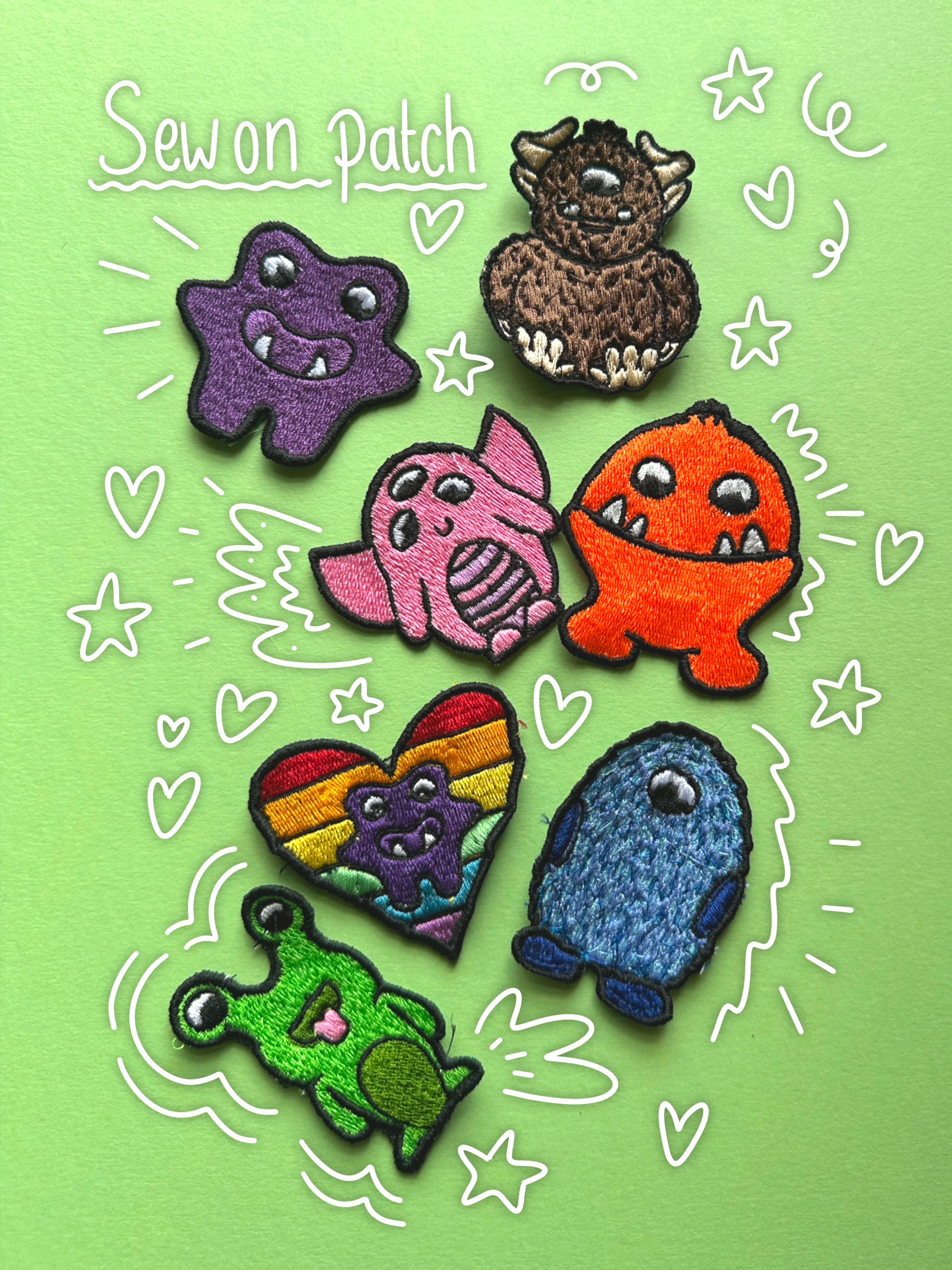Six colorful monster-shaped fabric patches arranged on a light green background with white hand-drawn doodles and the text 'Sew on Patch'. The patches include purple, brown, pink, orange, rainbow, blue, and green designs with embroidered details.